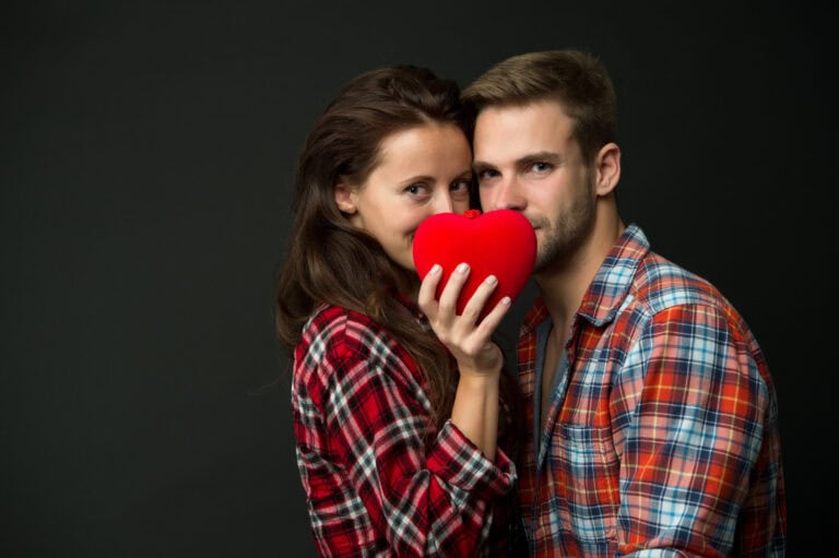 Young couple holding a red heart, symbolizing love and connection for herpes dating.